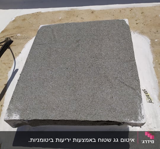 אריח בטון על גג עם חומר איטום לבן